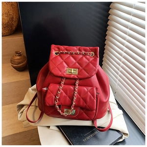 Detail of red quilted leather backpack featuring gold chain and turn-lock closure