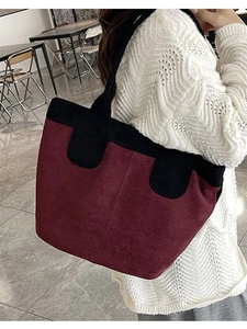 Minimalist burgundy suede tote bag with black trim and spacious shoulder bag design