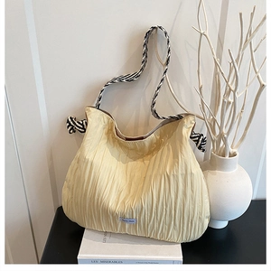 Détail du sac fourre-tout plissé jaune clair avec bandoulière en corde tressée bicolore
