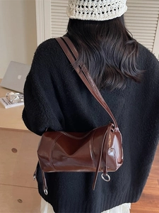 Retro deep brown cylinder pillow bag with glossy finish and silver ring strap detail