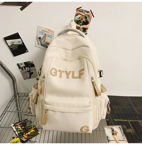 Detail of cream white backpack with front GTYLF lettering and multi-pocket design