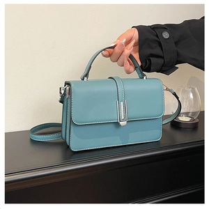 Detailed shot of Morandi blue handbag with silver vertical metal buckle and leather handle
