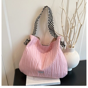 Détail du sac cabas plissé rose avec bandoulières tissées et nœuds latéraux