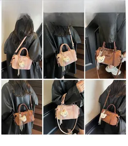 Detail shots of pink and brown Boston bags with bear charms worn by a model