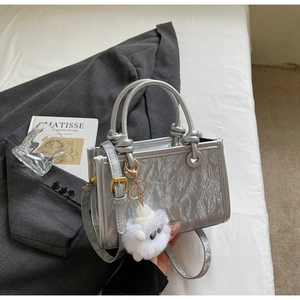 Close-up of silver textured handbag with metallic PU leather and knotted handle detail