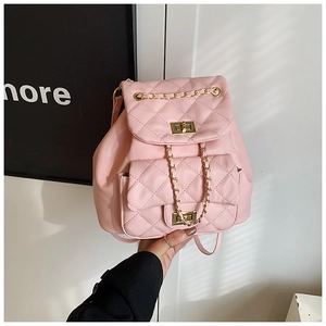 Close-up of pink quilted mini backpack with golden metal twist locks and chain details
