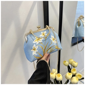 Detail of light blue floral embroidery and gold metal clasp on retro cheongsam bag