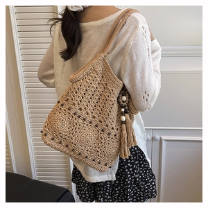 Detail shot of handwoven tote bag featuring crochet patterns and long fringe tassels