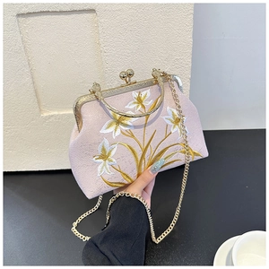 Detail of pink embroidered lily flower pattern on a vintage style crossbody bag