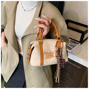 Detail einer beigen Boston-Tasche aus Wildleder mit braunem Leder-Patchwork und Stickerei