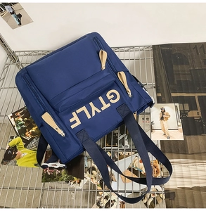 Detailed top view of a navy blue nylon backpack featuring durable handles and leather zip pulls