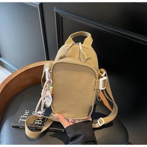 Detail of khaki crinkle nylon mini bag with 1865 charm and white adjustable buckle