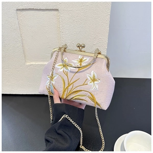 Detail of pink vintage qipao bag with white lily embroidery and gold metal clasp