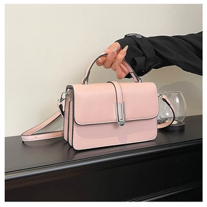 Detailed view of pink crossbody bag with silver metal buckle and textured PU finish