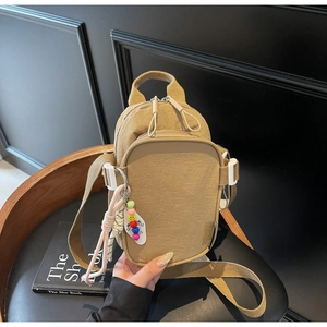 Detail of khaki nylon mini bag with pleated texture, pocket sections and bead charms