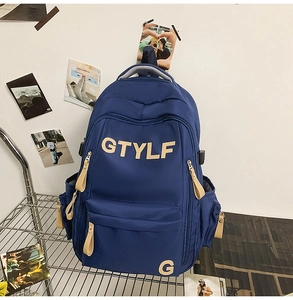 Detail of navy blue student backpack showing durable fabric and GTYLF logo on metal rack