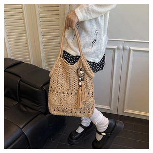 Detail of woven straw tote bag with circle patterns and beaded tassel accessory