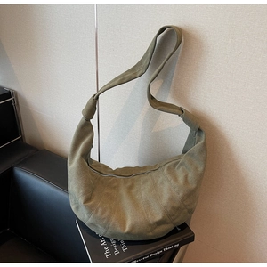 Detail of olive green canvas croissant bag showing pleated texture and sturdy knot strap