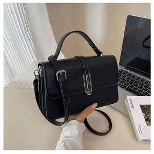 Macro view of black leather handbag with silver lock and detailed stitching texture