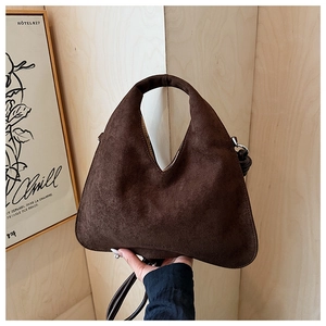 Macro detail of dark brown frosted leather shoulder bag with smooth integrated stitching