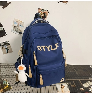 Detail of navy blue school backpack with GTYLF logo and white plush duck charm accessory