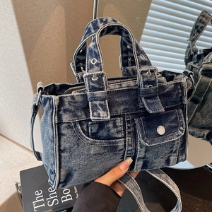 Vintage washed denim motorcycle tote bag with metallic buckles and adjustable strap