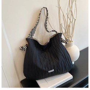 Détail du sac cabas nuage noir avec texture plissée et bandoulière tissée