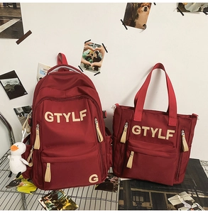 Detail showing burgundy high-capacity backpack and matching tote bag with GTYLF print