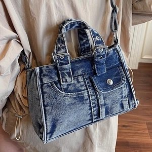 Washed dark blue denim tote bag with utility pockets and crossbody strap for street style