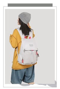 Detail of grey canvas travel backpack with red handle contrast and drawstring closure