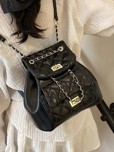 Quilted black leather backpack featuring classic diamond stitching and metal chain straps