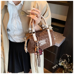 Close-up of mini Boston bag with leopard print, white leather trim and cute bear charm
