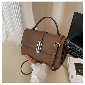 Detail view of a vintage brown matte leather handbag with silver clasp and top handle
