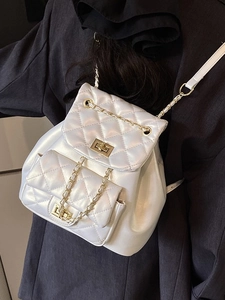 Quilted pearl white bucket backpack with gold chain straps and turn-lock closure
