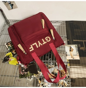 Top view of a burgundy canvas backpack with GTYLF lettering on a silver metal grid