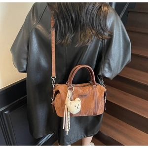 Caramel nylon crossbody bag with pleated texture and plush bear charm on model