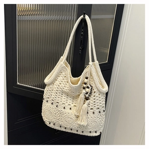 Close-up of handmade woven cotton tote bag with crochet floral patterns and wood beads