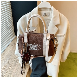 Detail der Boston-Tasche mit Leopardenmuster, Stickerei und Bärenanhänger im Alltag