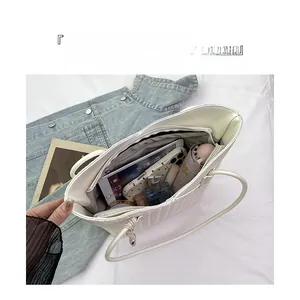 Top view of white quilted tote bag interior showing large capacity and internal compartments