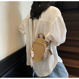 Close-up of khaki mini crossbody bag with colorful beads and white quick-release buckle