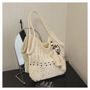 Detail of bohemian crochet tote bag with hollow flower patterns and wooden beads decorations