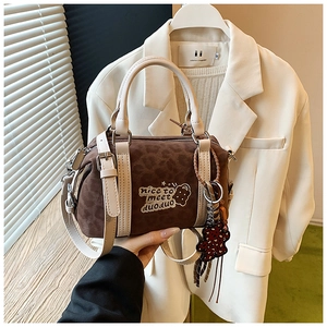 Detail der Boston Bag mit Leoparden-Samt-Textur, hellen Griffen und Bärenanhänger