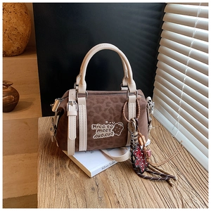 Detail einer braunen Boston Bag mit Leopardenmuster, Stickerei und einem Taschenanhänger