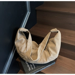 Close-up of khaki crescent canvas bag showing fabric texture and metal zipper detail
