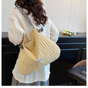 Détail du sac fourre-tout plissé beige avec bandoulière en sergé noir et blanc