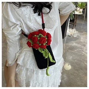 Detail of handmade crochet phone bag featuring 3D red roses on a white lace dress