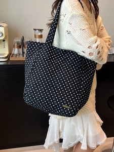 Schicke schwarz-weiße Polka-Dot Tragetasche mit goldener Logoplatte für urbane Freizeit