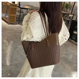 Detail of dark brown woven texture tote bag showing fine craftsmanship and leather trim