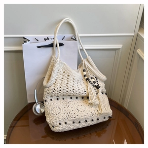 Detail of crochet tote bag featuring intricate hollow knit patterns and wooden bead accents