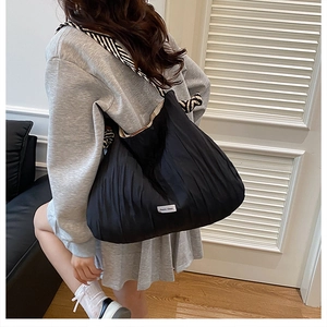 Grand sac cabas noir plissé avec bandoulière zébrée porté par un mannequin femme